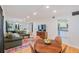 Open-concept living room with hardwood floors, a green sofa, and a view into the adjacent modern kitchen at 4060 Haverhill Ne Dr # F, Atlanta, GA 30342