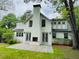 Backyard featuring a white painted brick house, fireplace, stone patio, and green lawn at 509 Ponce De Leon Pl, Decatur, GA 30030