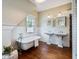 A bright bathroom features a clawfoot tub, double sink vanity and wainscoting at 509 Ponce De Leon Pl, Decatur, GA 30030