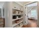 Bathroom with built-in shelving and a view of the tub and window through open french doors at 509 Ponce De Leon Pl, Decatur, GA 30030