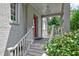 Traditional front porch featuring brick, white railing, columns, and a red door at 509 Ponce De Leon Pl, Decatur, GA 30030