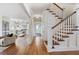 Inviting hallway featuring hardwood floors, elegant staircase, and open view to the modern kitchen with stainless steel appliances at 509 Ponce De Leon Pl, Decatur, GA 30030
