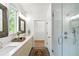 Modern bathroom featuring double sinks, a glass-enclosed shower, and access to a walk-in closet at 520 Wabash Ne Ave # B, Atlanta, GA 30312