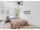 Cozy bedroom featuring a floral bedspread, a ceiling fan, neutral carpet, and a window at 1914 Lakeshore Overlook Nw Cir, Kennesaw, GA 30152