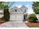 Charming two-story home with a two car garage and manicured landscaping and inviting curb appeal at 212 Regent Sq, Woodstock, GA 30188