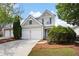 Charming two-story home with a two car garage and manicured landscaping and inviting curb appeal at 212 Regent Sq, Woodstock, GA 30188