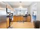 Kitchen with stainless steel appliances, granite countertops, and hardwood floors leads to the living room at 212 Regent Sq, Woodstock, GA 30188