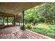 Covered patio with brick flooring, steps to a backyard with basketball and lush landscaping at 2469 Elizabeth Ann Ne Ln, Atlanta, GA 30324