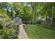 Spacious backyard with a fire pit and a shed, surrounded by lush greenery, perfect for relaxation and entertainment at 416 2Nd Ave, Decatur, GA 30030