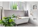 Bathroom featuring white subway tiles, a soaking tub, grey tile floors, and a window at 416 2Nd Ave, Decatur, GA 30030