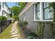 Side exterior featuring gray brick, black framed windows, lush landscaping, and stone pathway at 416 2Nd Ave, Decatur, GA 30030
