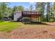 Exterior view of a backyard with a two-story deck with a hot tub underneath and a lush green lawn at 1094 Plantation Ct, Villa Rica, GA 30180