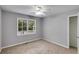 Bedroom with neutral carpeting, closet, and a bright window overlooking the outdoor landscape at 1094 Plantation Ct, Villa Rica, GA 30180