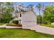 Exterior view of a two-story home with a three-car garage, white siding and manicured lawn at 1094 Plantation Ct, Villa Rica, GA 30180