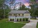 Charming home featuring a welcoming front porch and meticulously landscaped front yard and driveway at 1094 Plantation Ct, Villa Rica, GA 30180