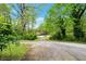 Long driveway leads to a yellow house framed by mature trees and green landscape at 4050 Old Fairburn Rd, Atlanta, GA 30349