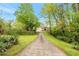 Long driveway leading to a charming home surrounded by mature trees and lush landscaping at 4050 Old Fairburn Rd, Atlanta, GA 30349