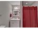 Bathroom with white vanity, sink, and mirror with red curtain over the bath tub area at 4490 Highway 138 Sw, Stockbridge, GA 30281