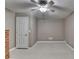 Bedroom with a ceiling fan for comfort, neutral walls, and a white door, plus wooden dresser at 4490 Highway 138 Sw, Stockbridge, GA 30281