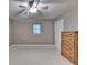 Bedroom features neutral colored walls and carpet with a ceiling fan and a wooden dresser at 4490 Highway 138 Sw, Stockbridge, GA 30281