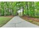 Concrete driveway surrounded by lush, mature trees at 4490 Highway 138 Sw, Stockbridge, GA 30281