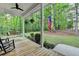 Relaxing front porch with a swing, American flag, and views of nature at 4490 Highway 138 Sw, Stockbridge, GA 30281