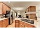 Spacious kitchen featuring stainless steel appliances, a brick fireplace, and an island cooktop at 4490 Highway 138 Sw, Stockbridge, GA 30281