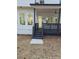 Covered back porch featuring black railings, ceiling fan, and access steps to the backyard; white siding and trim at 503 Glendale Rd, Scottdale, GA 30079