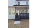 View of back porch with black railings and a ceiling fan; access to interior and steps down to the backyard at 503 Glendale Rd, Scottdale, GA 30079