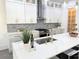A bright modern kitchen featuring an expansive island, stylish pendant lights, and stainless steel appliances at 503 Glendale Rd, Scottdale, GA 30079