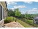 Spacious backyard featuring a stone patio, well-manicured lawn, and a wrought iron fence at 5695 Overlook Station Dr, Suwanee, GA 30024