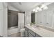 This bathroom features a vanity with granite countertop and a shower and tub combination at 5695 Overlook Station Dr, Suwanee, GA 30024