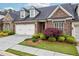 Charming home featuring a well-manicured lawn, stone accents, and a two-car garage at 5695 Overlook Station Dr, Suwanee, GA 30024