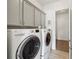 Well-equipped laundry room featuring modern washer and dryer with built-in cabinetry and ample storage space at 5695 Overlook Station Dr, Suwanee, GA 30024