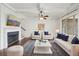 Bright living room with a fireplace, ceiling fan, and a blue and white rug, great for entertaining at 5695 Overlook Station Dr, Suwanee, GA 30024