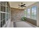 Relaxing sunroom featuring brick walls, ample windows offering bright light, and a ceiling fan at 5695 Overlook Station Dr, Suwanee, GA 30024