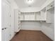 Spacious walk-in closet featuring carpet flooring and custom white shelving for organized storage at 5695 Overlook Station Dr, Suwanee, GA 30024