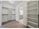 Spacious walk-in closet with shelving that provides direct access to the en-suite bathroom at 5695 Overlook Station Dr, Suwanee, GA 30024