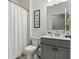 Clean bathroom with a toilet, vanity, and shower with a white curtain at 1180 Trident Maple, Lawrenceville, GA 30045