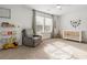 Charming Bedroom with a crib, soft carpet, and a comfortable reading chair with books nearby at 1180 Trident Maple, Lawrenceville, GA 30045