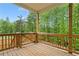 Relaxing deck area with wooden railings, fan, and an incredible view of the surrounding green trees at 1180 Trident Maple, Lawrenceville, GA 30045
