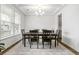 Elegant dining room featuring a dark wood table, six chairs, a chandelier, and bright natural light at 1180 Trident Maple, Lawrenceville, GA 30045