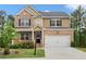 Charming two-story home featuring a brick and siding facade, a cozy front porch and a two-car garage at 1180 Trident Maple, Lawrenceville, GA 30045
