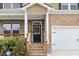 Inviting entryway showcasing a black front door with glass panels, brick steps, and manicured landscaping at 1180 Trident Maple, Lawrenceville, GA 30045