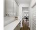Hallway view with white cabinets, black handles, tile backsplash, and wood floors at 1180 Trident Maple, Lawrenceville, GA 30045