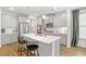 Spacious kitchen featuring gray cabinets, stainless steel appliances, a large island, and hardwood floors at 1180 Trident Maple, Lawrenceville, GA 30045