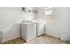 Practical laundry room with a washer, dryer, and shelving for convenient storage and organization at 1180 Trident Maple, Lawrenceville, GA 30045