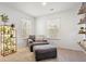 Cozy sitting room with a comfy chair, ottoman, multiple windows and shelves of books at 1180 Trident Maple, Lawrenceville, GA 30045