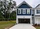 Modern townhome featuring a two-car garage, blue accents, and manicured lawn at 1964 Asher Ln # 47, Conyers, GA 30013
