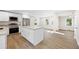 Open kitchen with white cabinets, stainless steel appliances, a kitchen island, and light wood flooring at 2805 Long Way, Decatur, GA 30032
